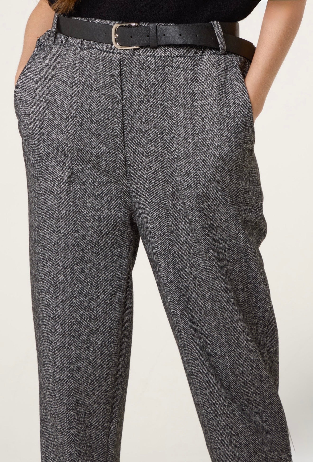 Close-up of Londra herringbone fabric and belt detail — elegant tailored trousers.