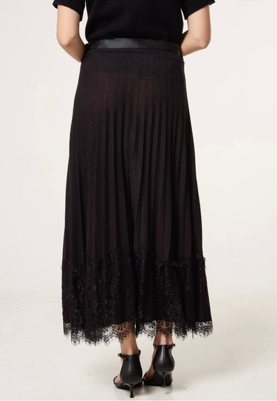 Close-up of Notte wool-blend pleated skirt with delicate lace hem — feminine smart-casual design.