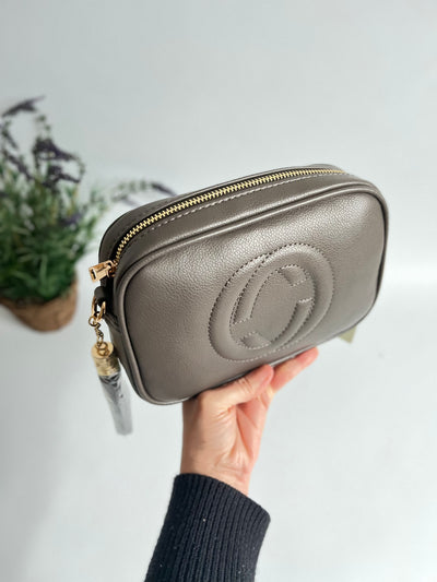 showing the zip details of the dark grey faux leather crossbody bag
